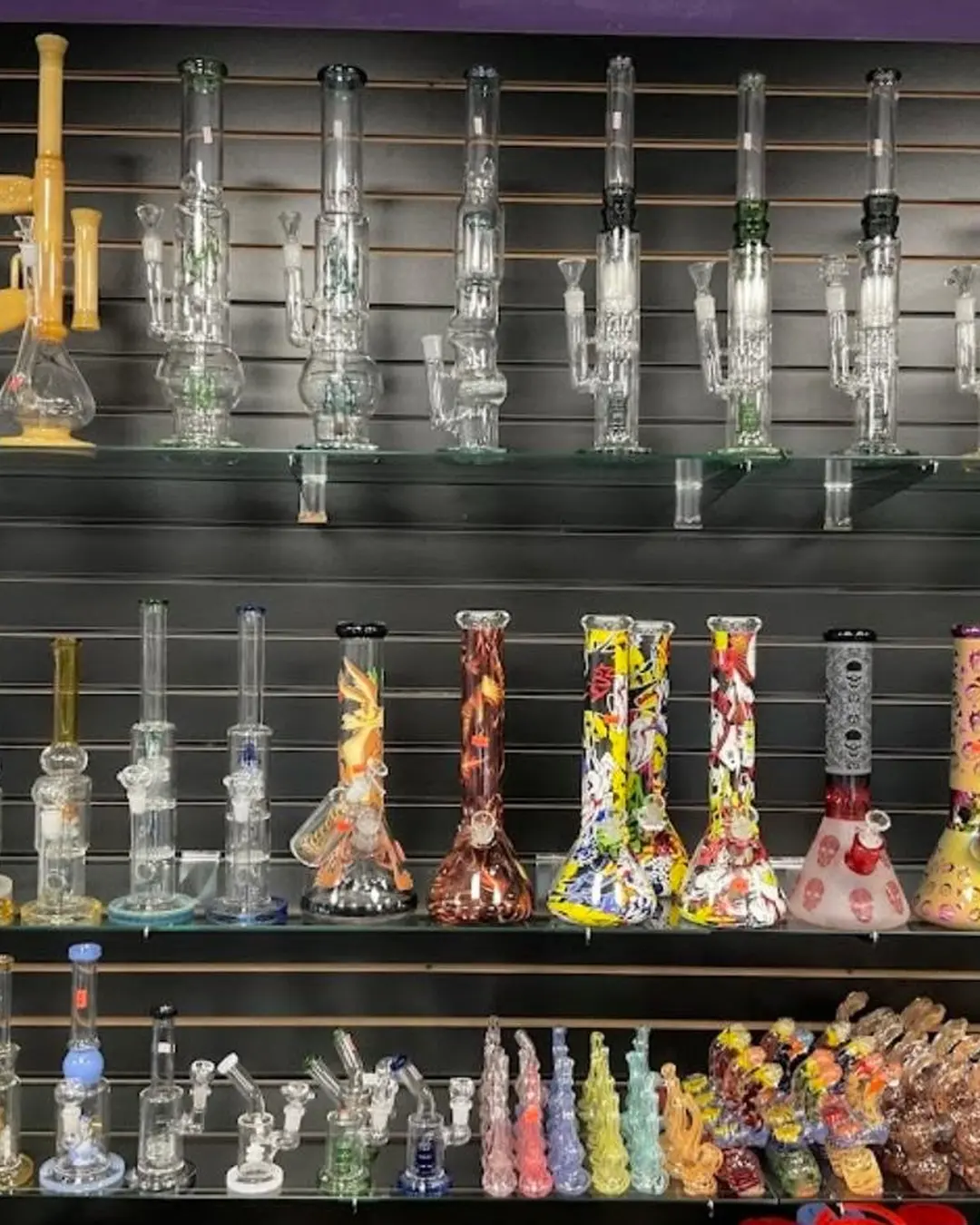 Colorful glass water pipes on black retail shelves