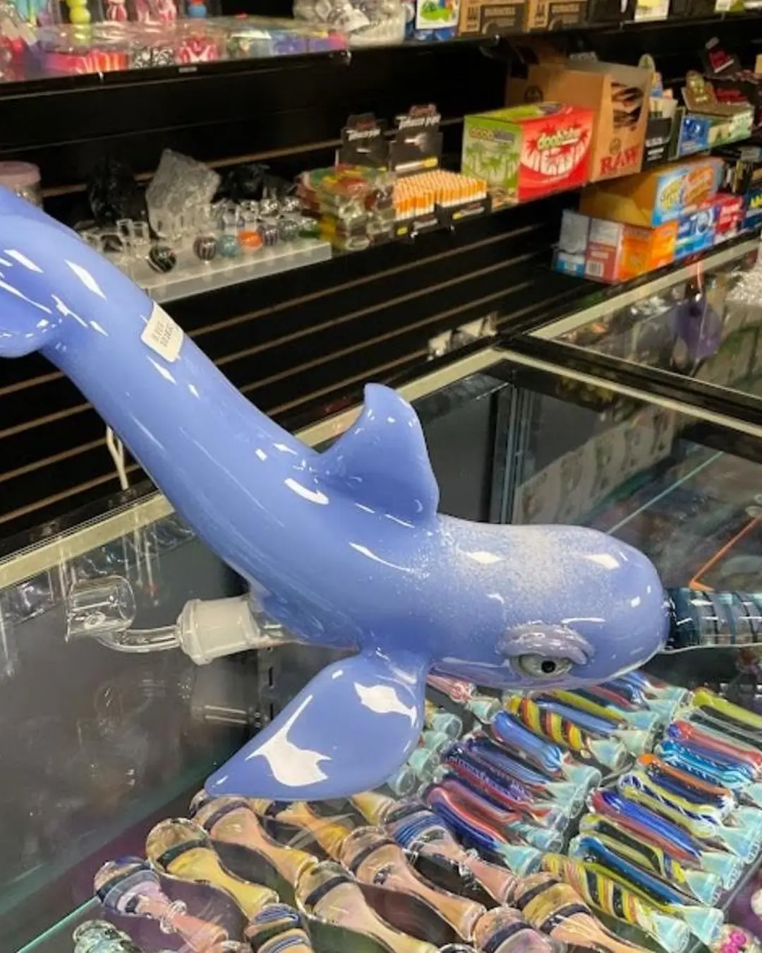 Blue glass water pipe beside other smoking accessories