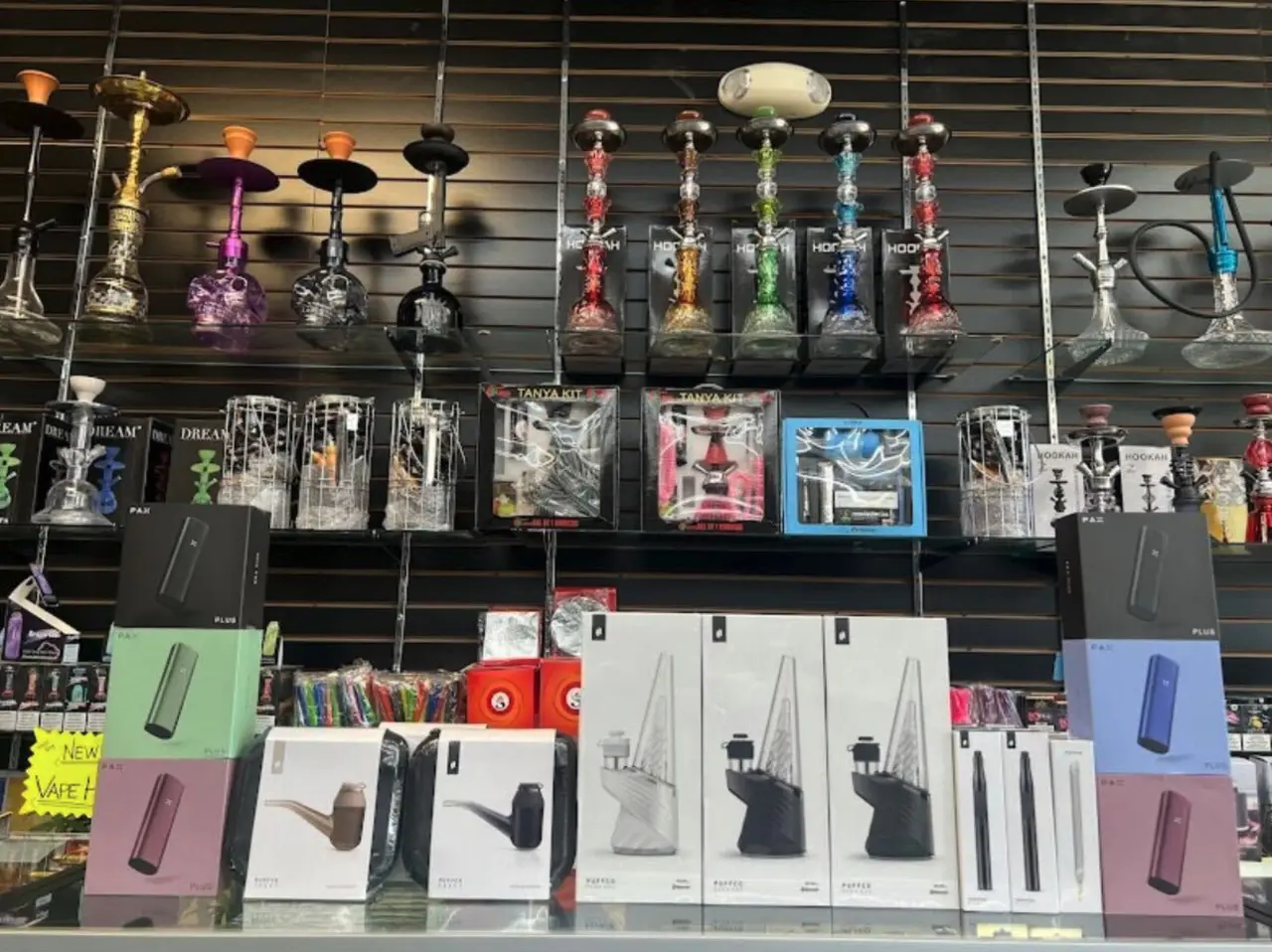 Hookahs above boxed products on a wall display